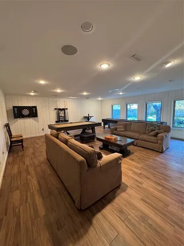a living room with furniture and a wooden floor