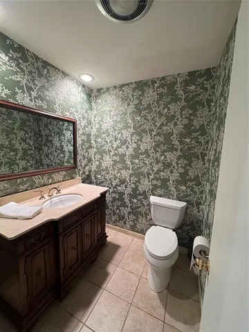 a bathroom with a granite countertop toilet and a sink