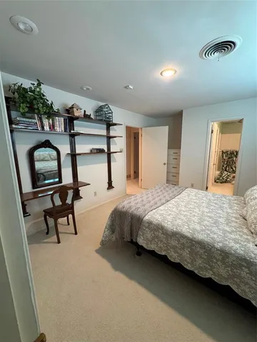 a bedroom with a bed a mirror and furniture