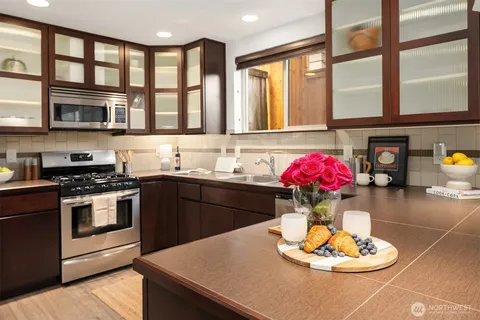 a kitchen with a stove a sink and a dining table with kitchen view