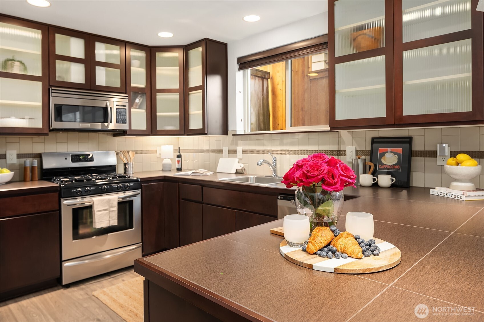5935 Fauntleroy Way Southwest, Unit A Seattle, WA 98136 - Photo 1 of 20 a kitchen with a stove a sink and a dining table with kitchen view