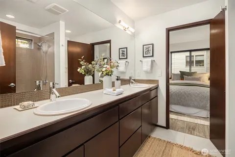 a bathroom with double vanity sinks and a mirror