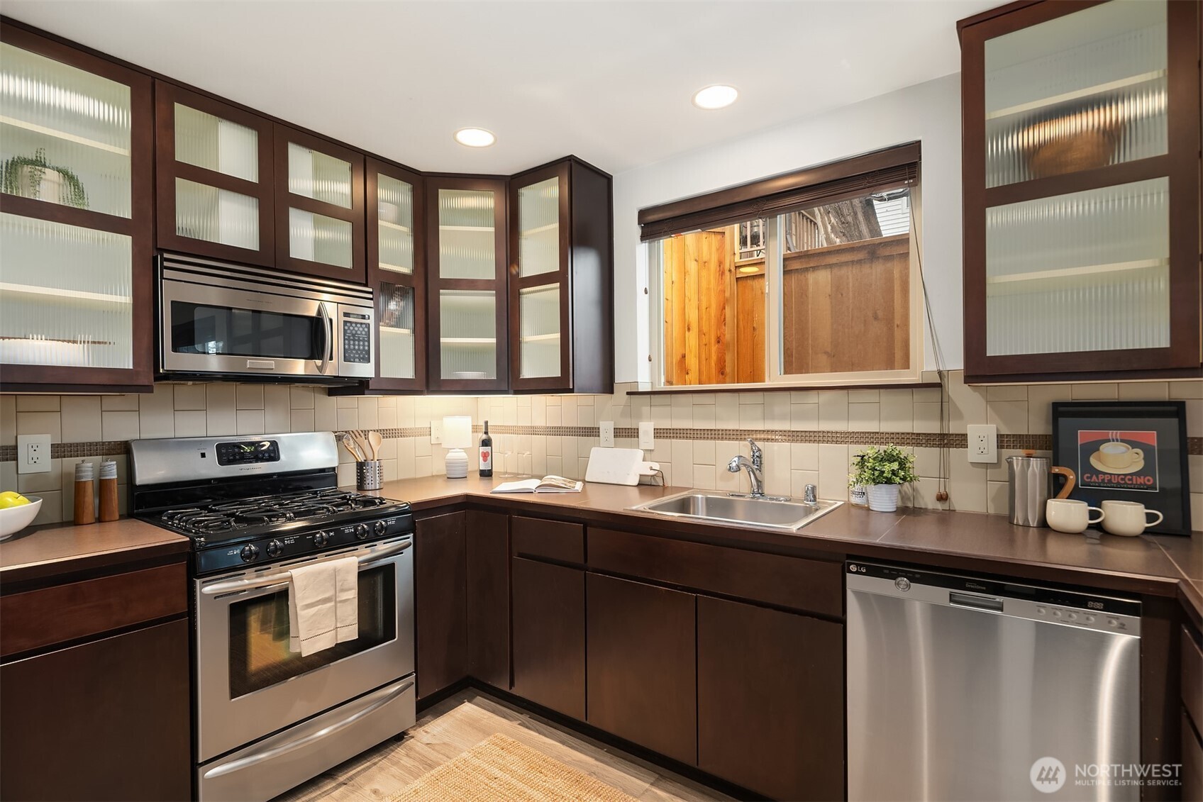 5935 Fauntleroy Way Southwest, Unit A Seattle, WA 98136 - Photo 2 of 20 a kitchen with stainless steel appliances granite countertop a sink stove cabinets and a microwave oven