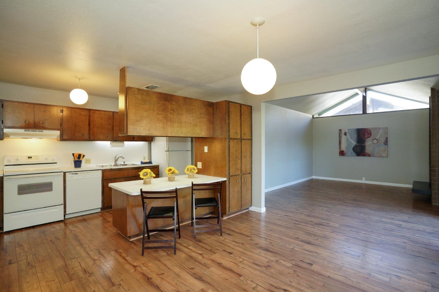 a kitchen with a sink cabinets and wooden floor