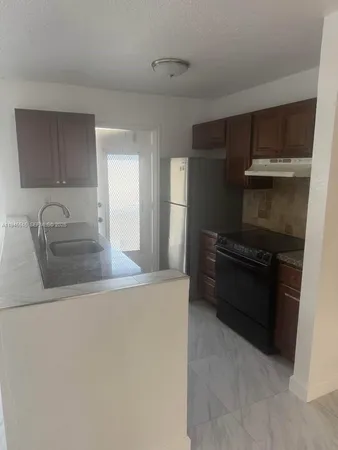 a kitchen with a refrigerator and a sink