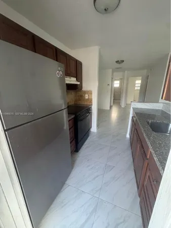 a large kitchen with a stove a refrigerator and a sink