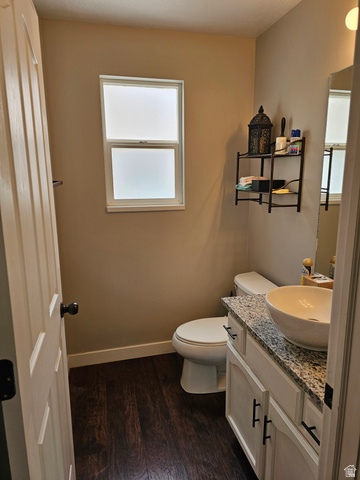 7481 Red Pine Road Eagle Mountain, UT 84005 - Photo 8 of 38 Main floor 1/2 Bathroom featuring wood-finish flooring, a white vanity with a granite-style countertop, a vessel sink, and a privacy window
