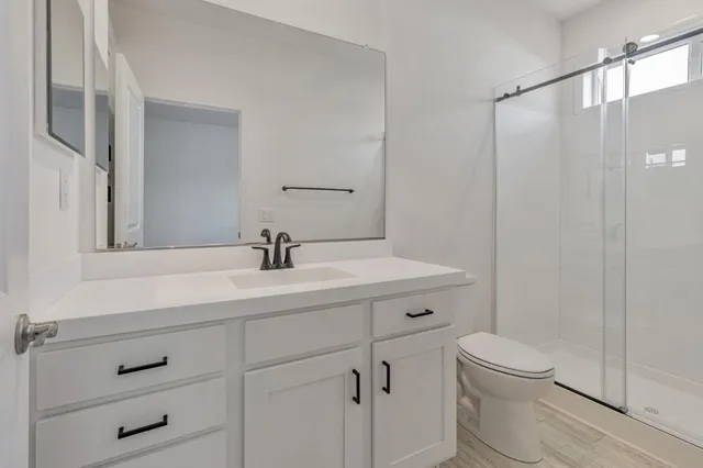 a bathroom with a sink a mirror a toilet and vanity