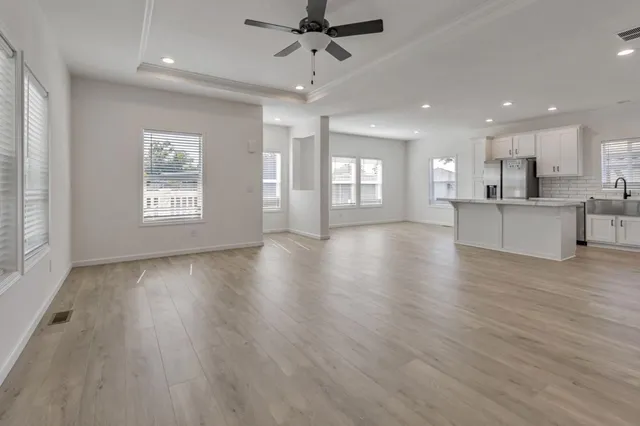 a view of an empty room with window and wooden floor