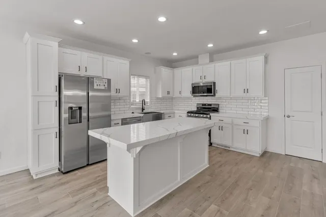 a kitchen with white cabinets and stainless steel appliances