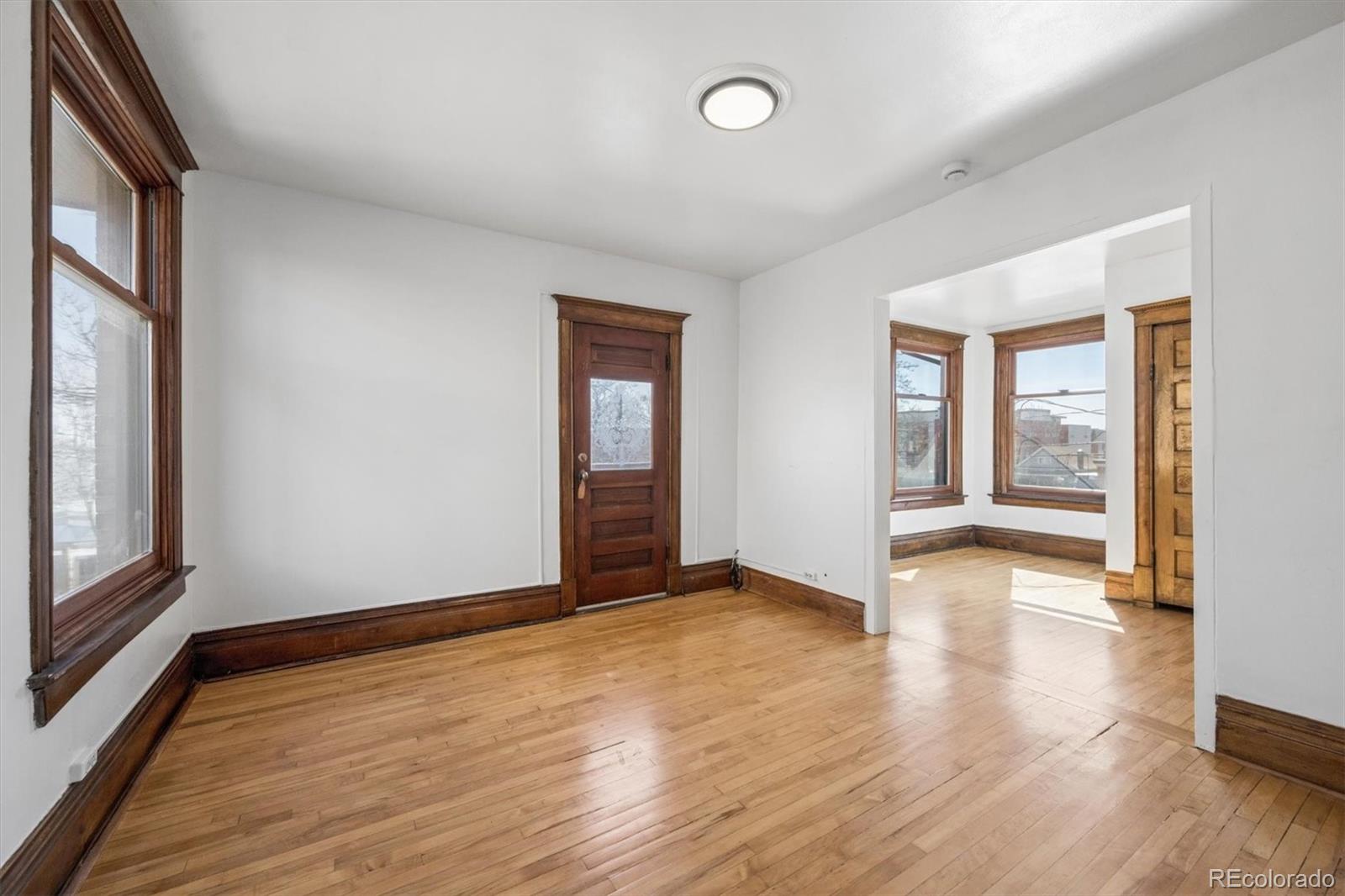 3828 Tejon Street Denver, CO 80211 - Photo 12 of 36 an empty room with wooden floor and windows