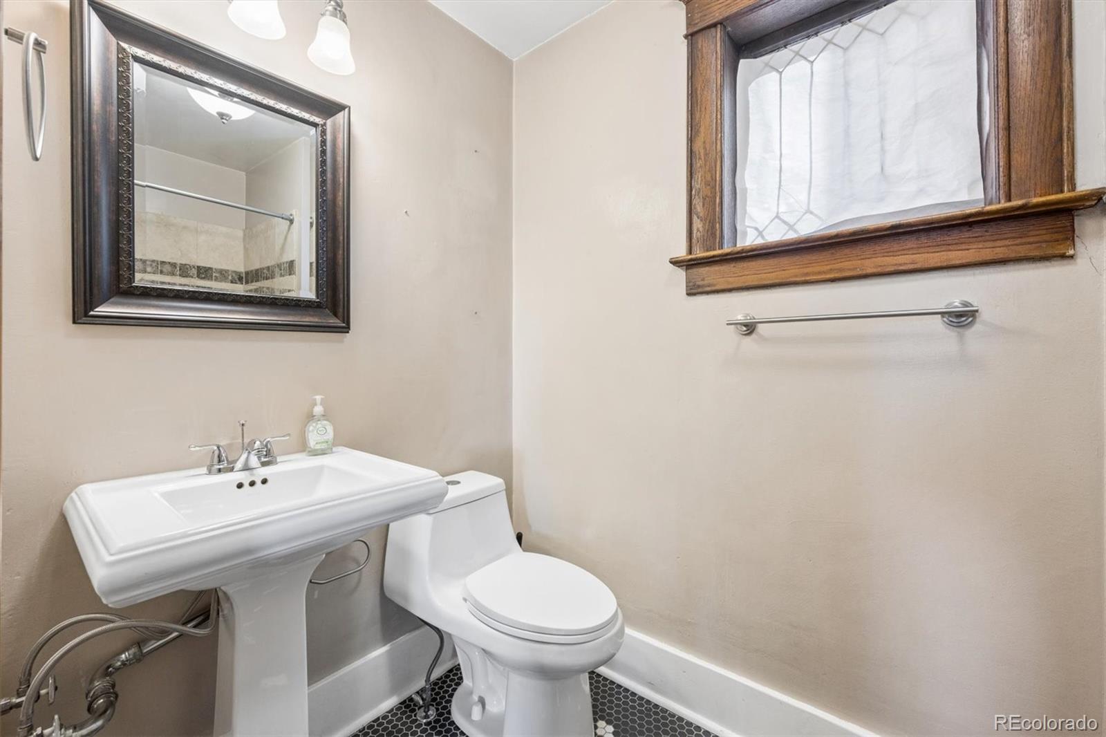 3828 Tejon Street Denver, CO 80211 - Photo 14 of 36 a bathroom with a toilet a sink and mirror