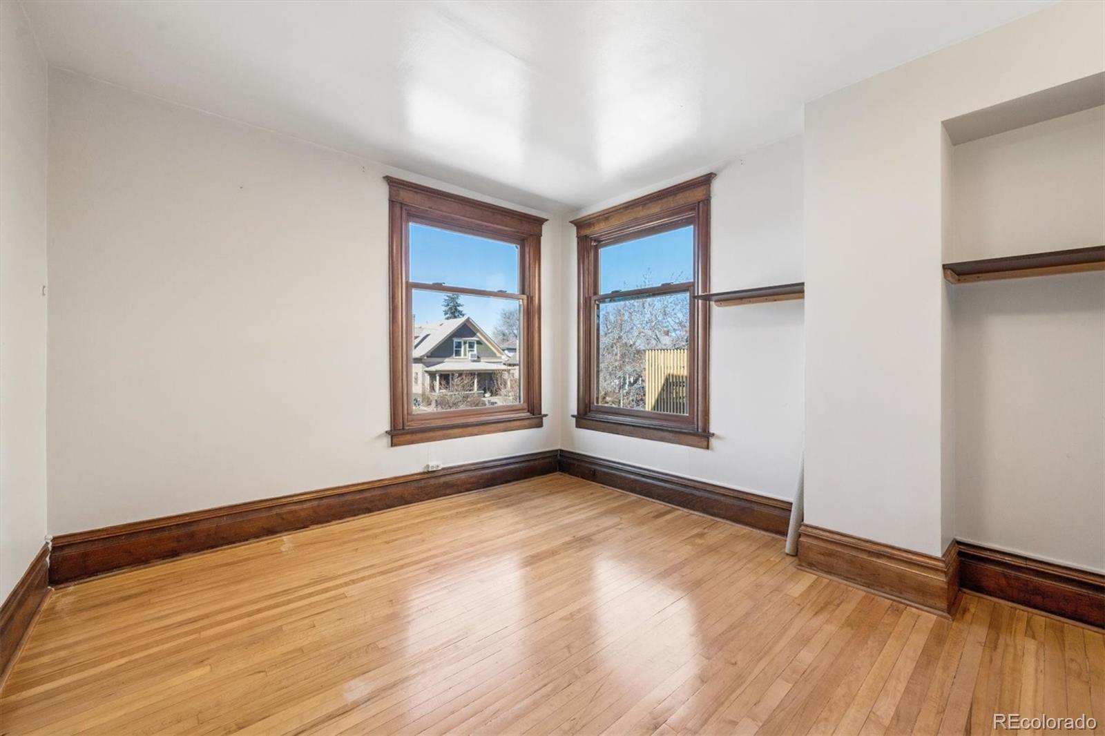3828 Tejon Street Denver, CO 80211 - Photo 17 of 36 an empty room with wooden floor and windows
