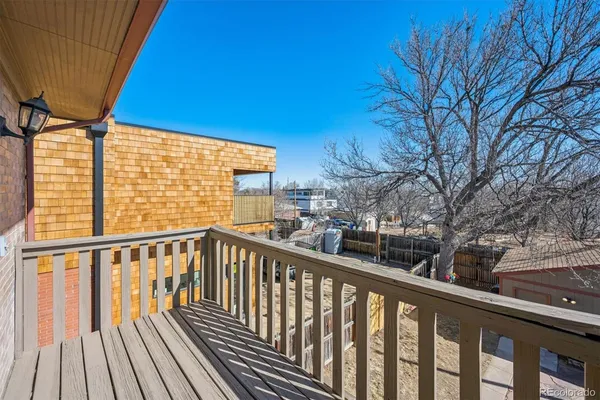 a view of a balcony with wooden floor and fence