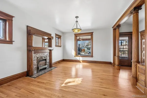a view of an empty room with window and wooden floor