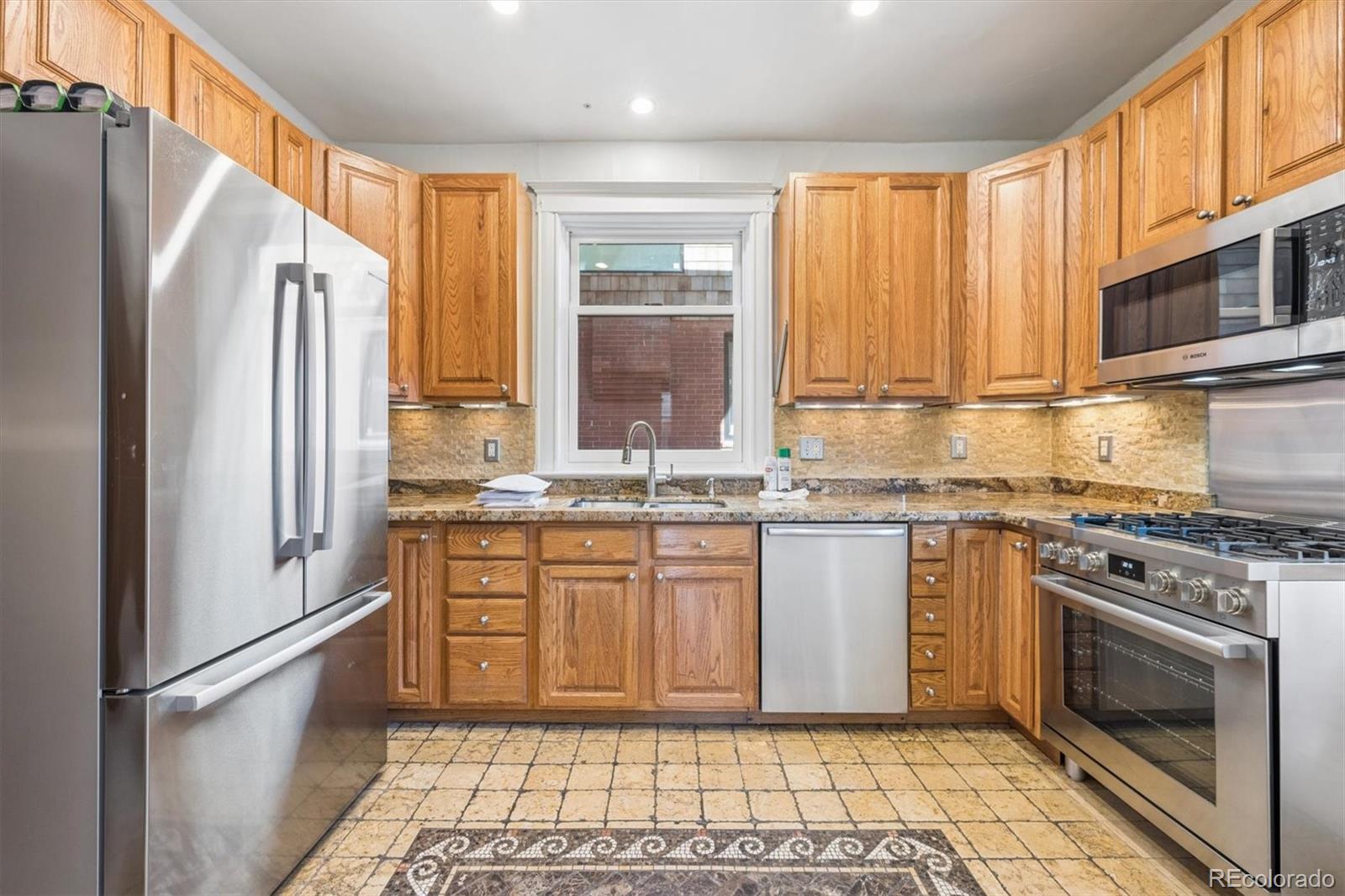 3828 Tejon Street Denver, CO 80211 - Photo 7 of 36 a kitchen with stainless steel appliances granite countertop a refrigerator a stove and a sink