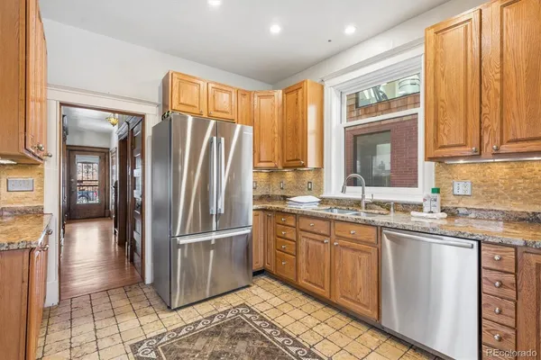 a kitchen with stainless steel appliances granite countertop a refrigerator and a sink