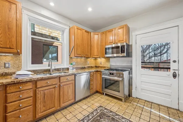 a kitchen with stainless steel appliances granite countertop a stove sink and cabinets