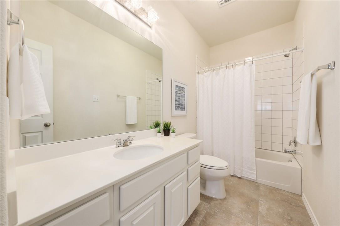 2105 Town Centre Drive, Unit 49 Round Rock, TX 78664 - Photo 14 of 22 a bathroom with a sink a toilet and shower curtain