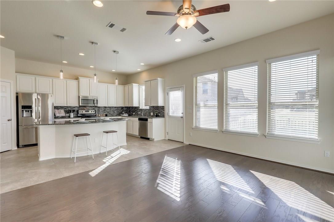 2105 Town Centre Drive, Unit 49 Round Rock, TX 78664 - Photo 5 of 22 a kitchen with stainless steel appliances granite countertop a refrigerator a sink dishwasher a stove and white cabinets with wooden floor