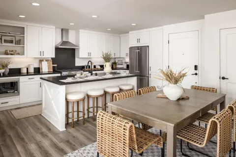 a view of kitchen with stainless steel appliances granite countertop a stove a sink a dining table and chairs