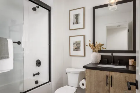 a bathroom with a granite countertop sink a mirror a shower and toilet