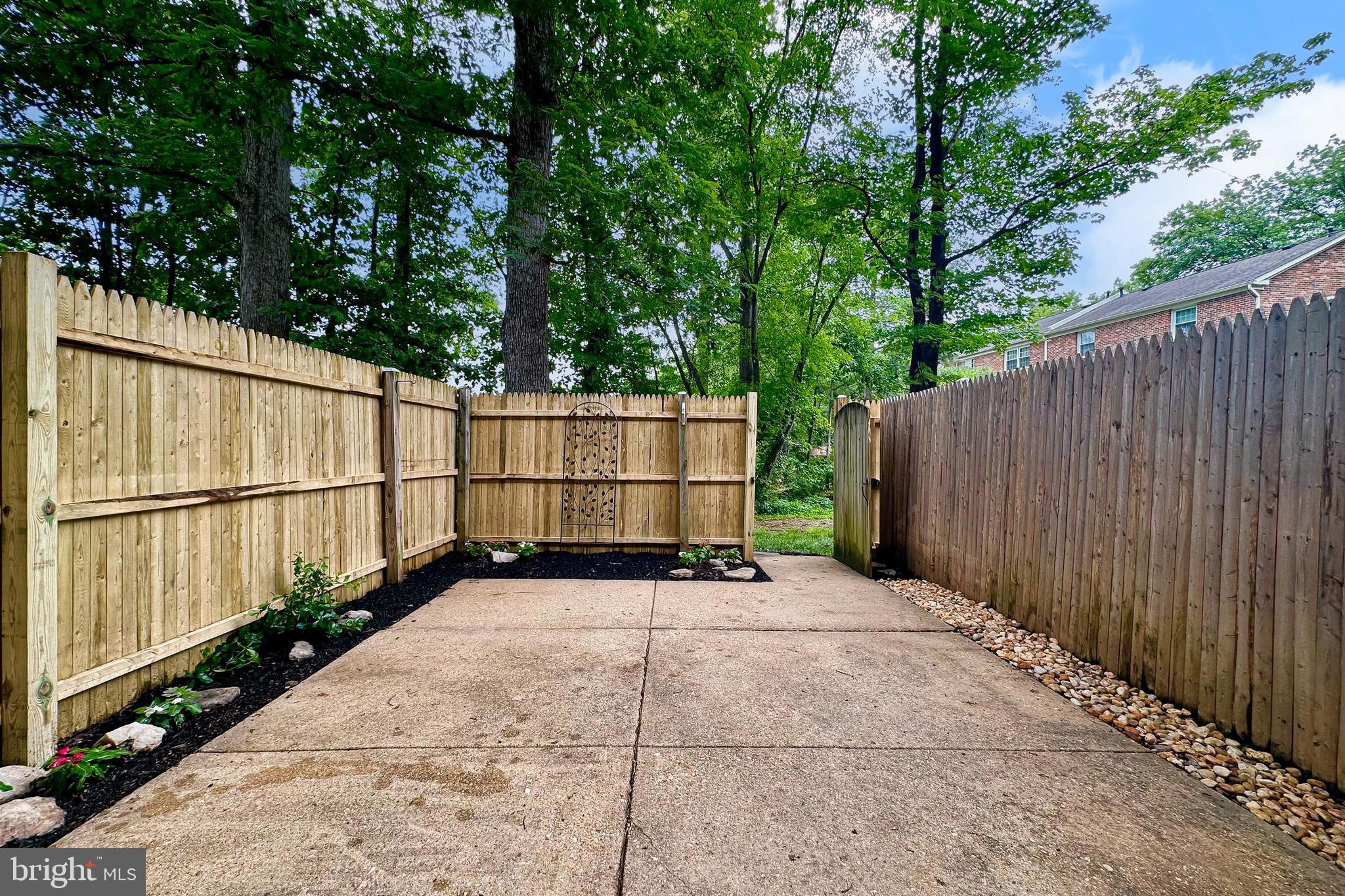 5833 Royal Ridge Drive, Unit 943 Springfield, VA 22152 - Photo 37 of 45 a view of a backyard with a fence and trees