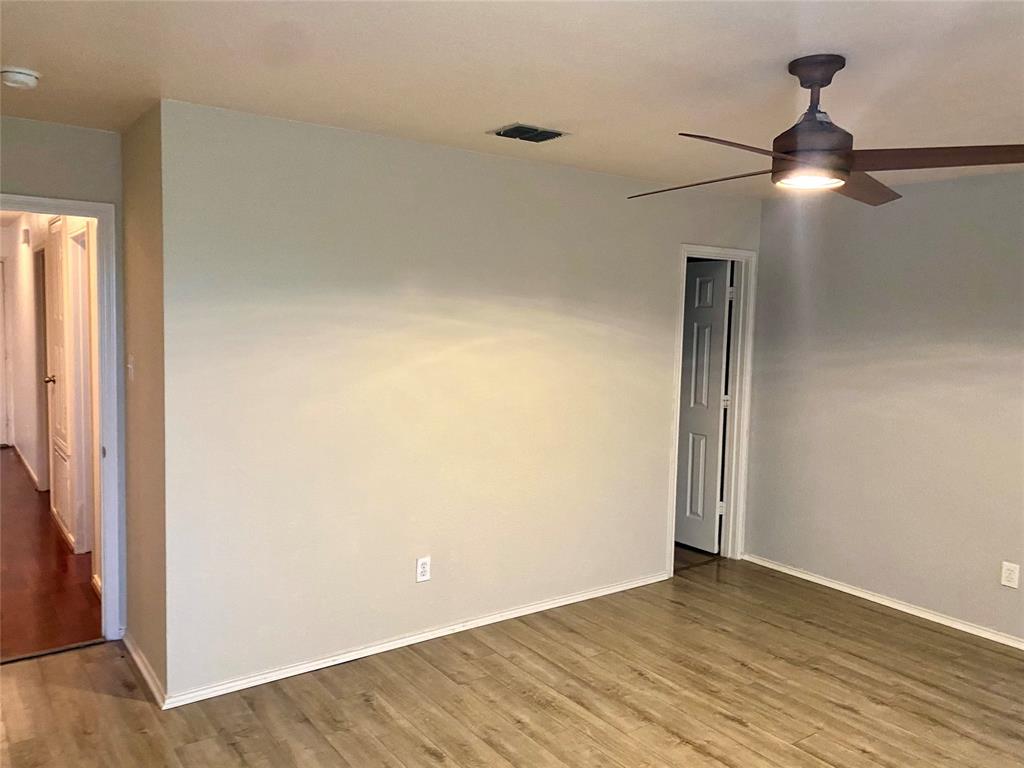 2533 Grand Gulf Road Fort Worth, TX 76123 - Photo 9 of 13 Spare room featuring wood finished floors, a ceiling fan, and a smoke detector
