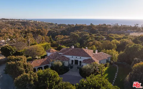 an aerial view of a house with a garden and lake view