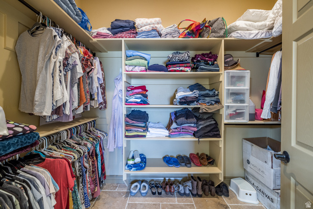 4635 East Sunny Acres Lane Moab, UT 84532 - Photo 53 of 56 Custom closet system featuring multiple hanging rods, integrated shelving, and stone-finish flooring