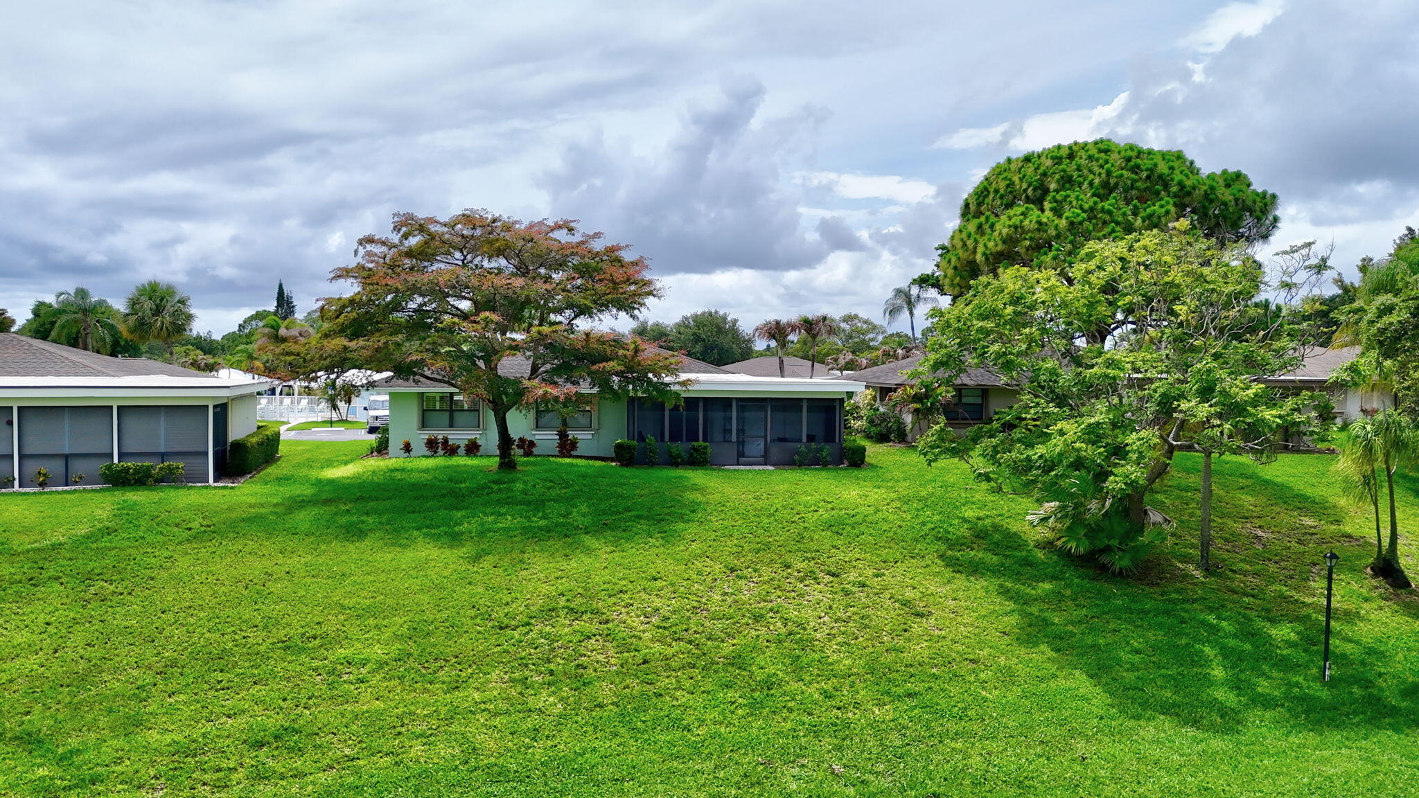 5251 Southeast Sea Island Way Stuart, FL 34997 - Photo 47 of 68 a view of a house with a big yard potted plants and a large tree