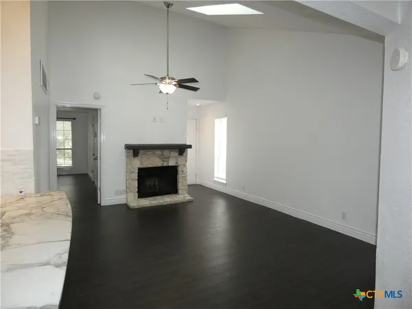 a view of a livingroom with a fireplace a chandelier and wooden floor