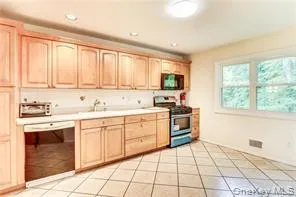 a kitchen with a stove a sink and a window