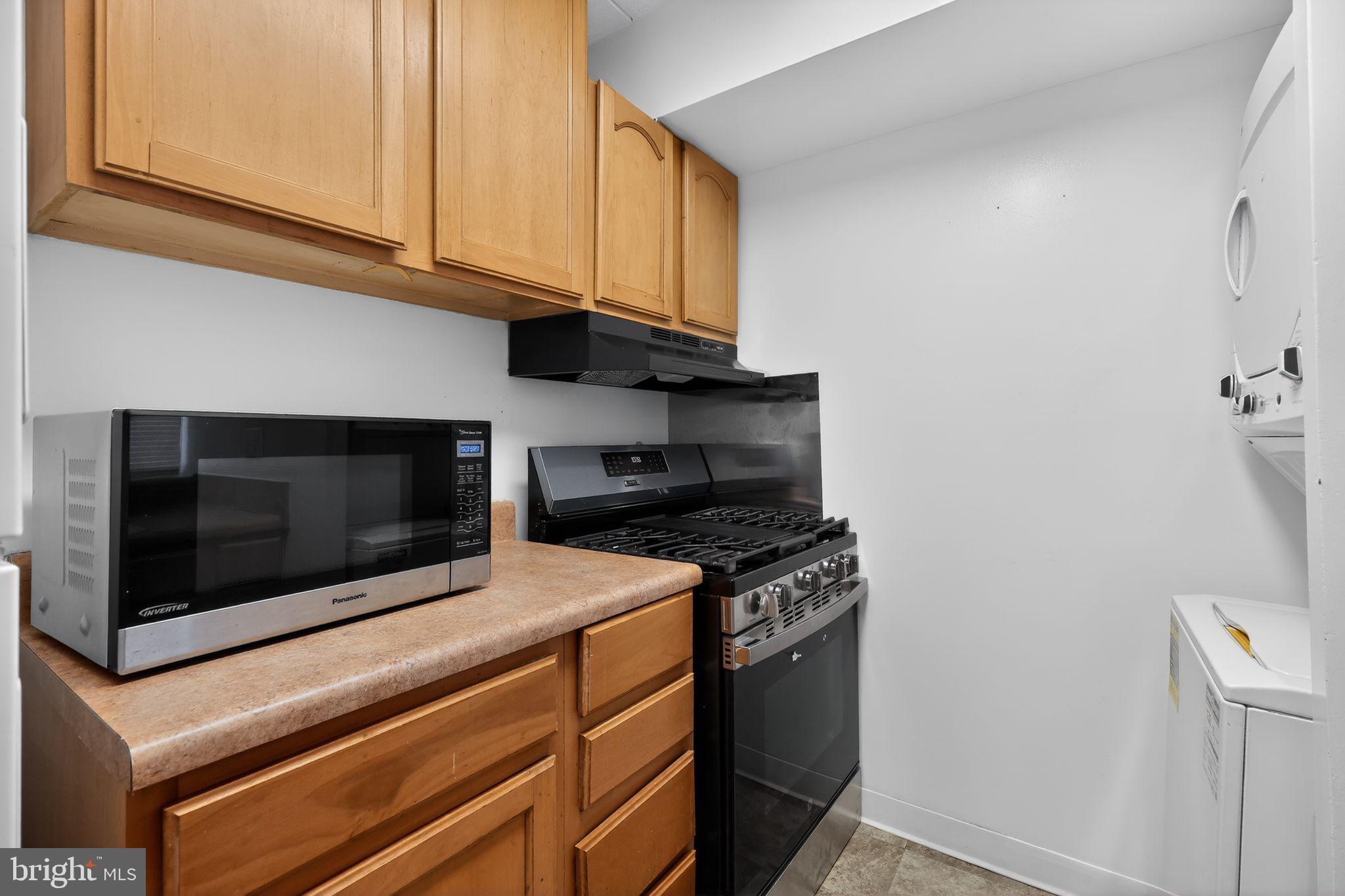 1619 Gainesville Street Southeast, Unit T Washington, DC 20020 - Photo 9 of 14 a kitchen with stainless steel appliances granite countertop white cabinets and a stove top oven