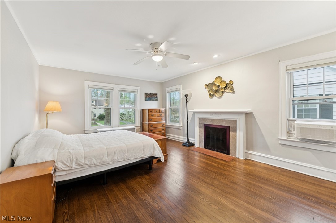 2925 East Overlook Road Cleveland Heights, OH 44118 - Photo 19 of 48 Living space featuring hardwood flooring, a ceiling fan, a fireplace with a mantel, and windows providing natural light