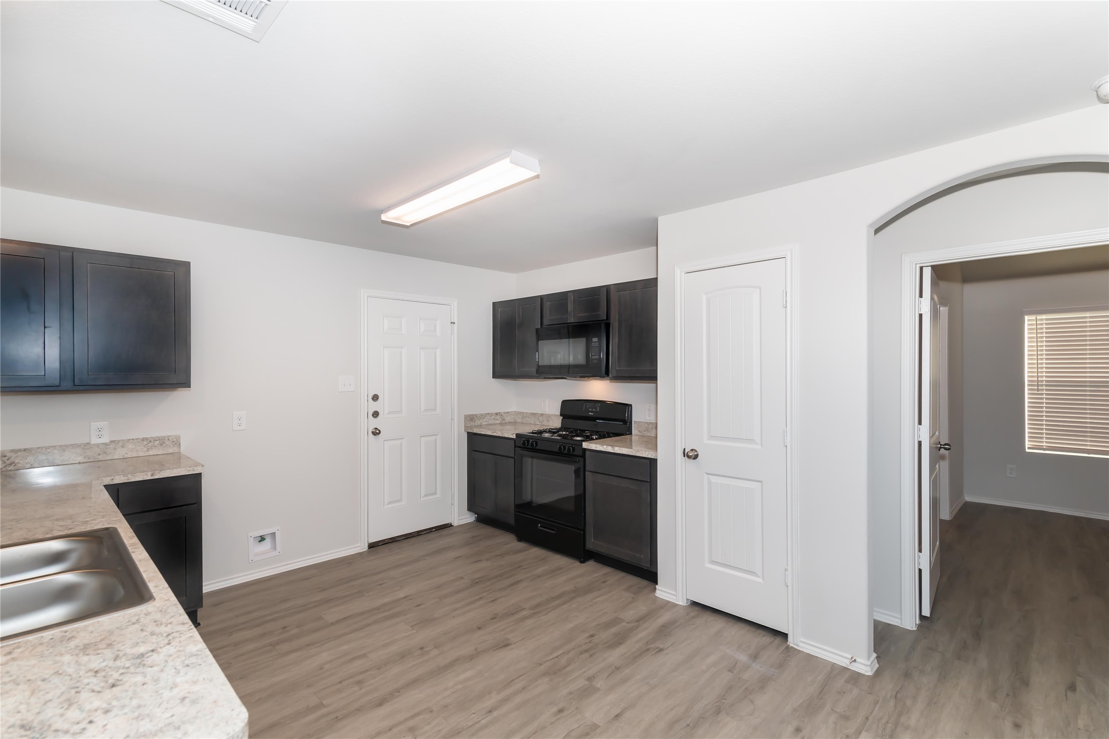 2268 Onyx Lane Conroe, TX 77301 - Photo 5 of 17 a kitchen with stainless steel appliances granite countertop a stove refrigerator and microwave