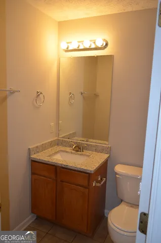 a bathroom with a granite countertop sink toilet and a mirror