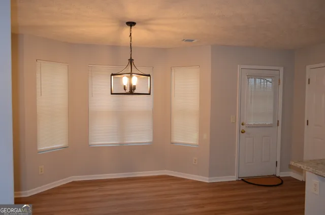 a view of a room with wooden floor closet and windows