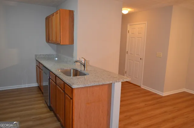 a kitchen with a sink a mirror and wooden floor