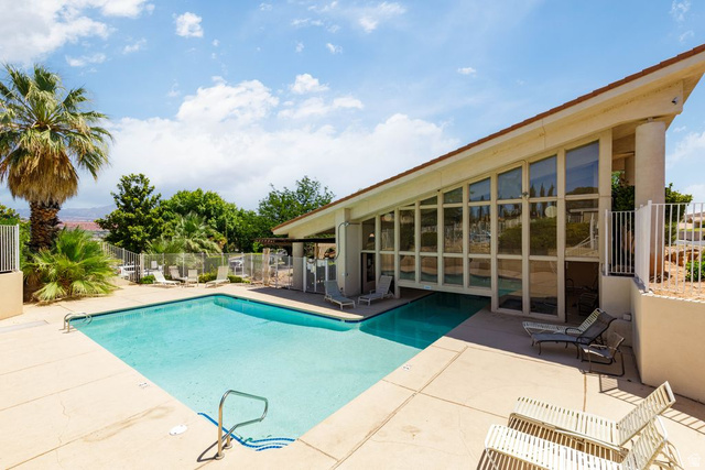 2158 Balboa Way St. George, UT 84770 - Photo 3 of 40 Outdoor swimming pool with concrete decking, surrounded by mature palm trees and lush landscaping