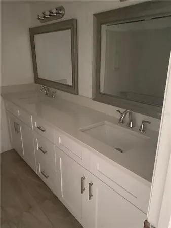 a bathroom with double vanity sink and mirror