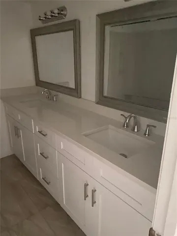 a bathroom with double vanity sink and mirror