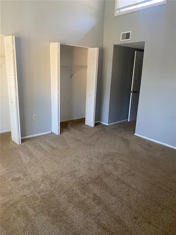 an empty room with closet and mirror