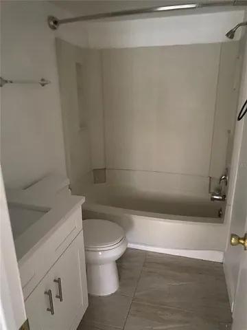 a white toilet sitting next to a bath tub