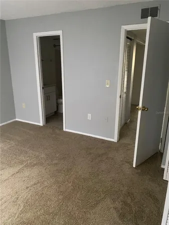 an empty room with closet and mirror