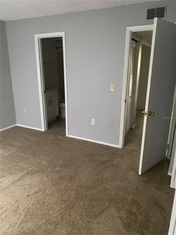 an empty room with closet and mirror