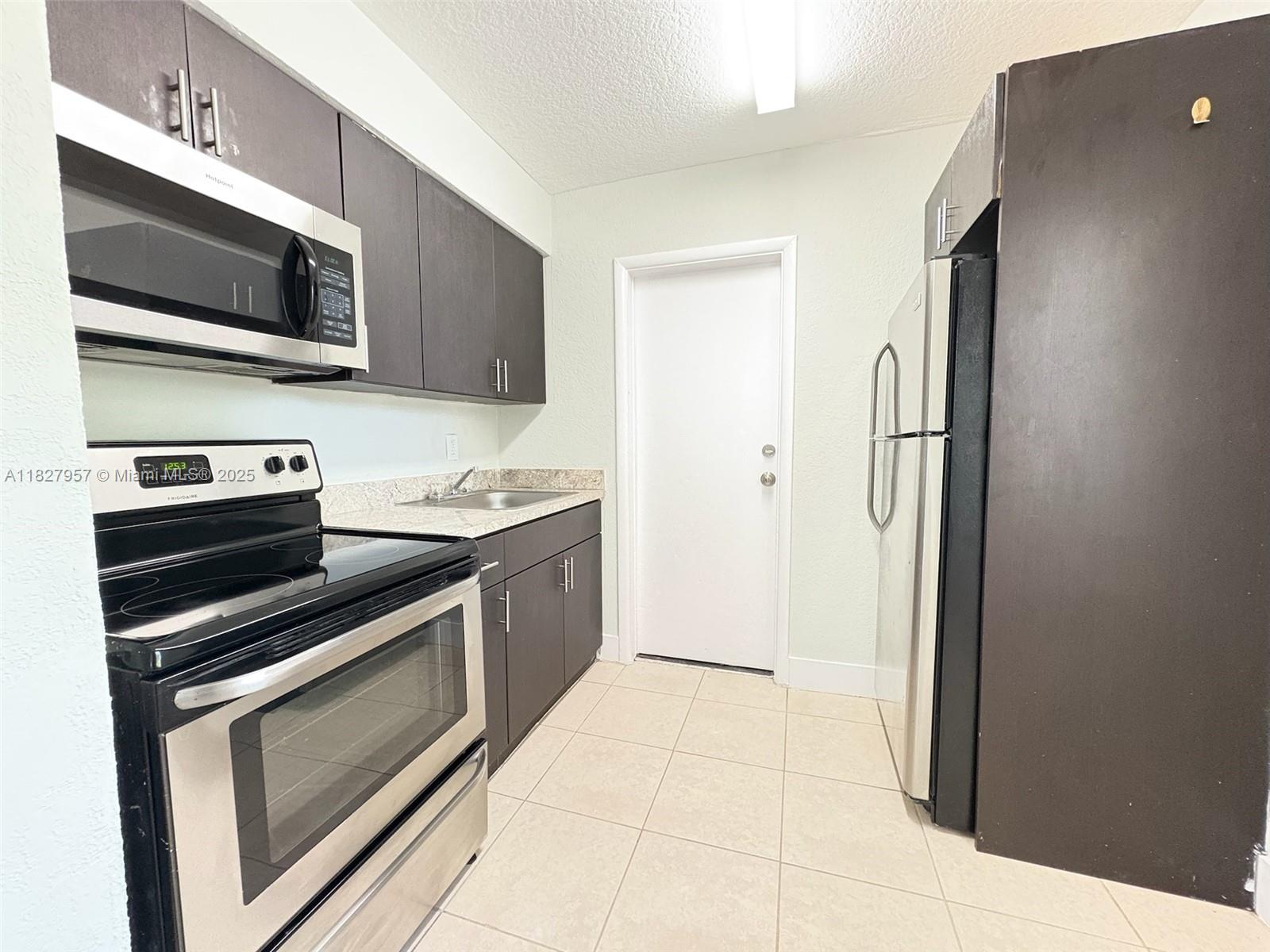 2840 Funston Street, Unit B Hollywood, FL 33020 - Photo 2 of 10 a kitchen with a refrigerator stove and microwave