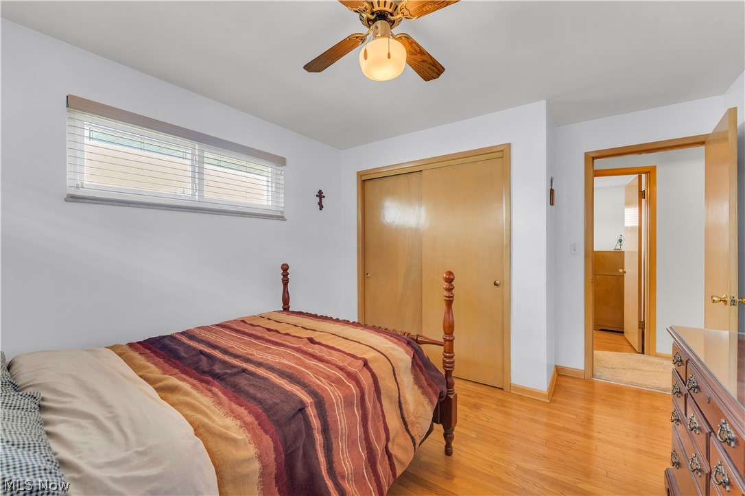 3023 Norris Avenue Cleveland, OH 44134 - Photo 20 of 41 Bedroom featuring wood-finish flooring, a ceiling fan with integrated lighting, a horizontal window with blinds, and a sliding door closet