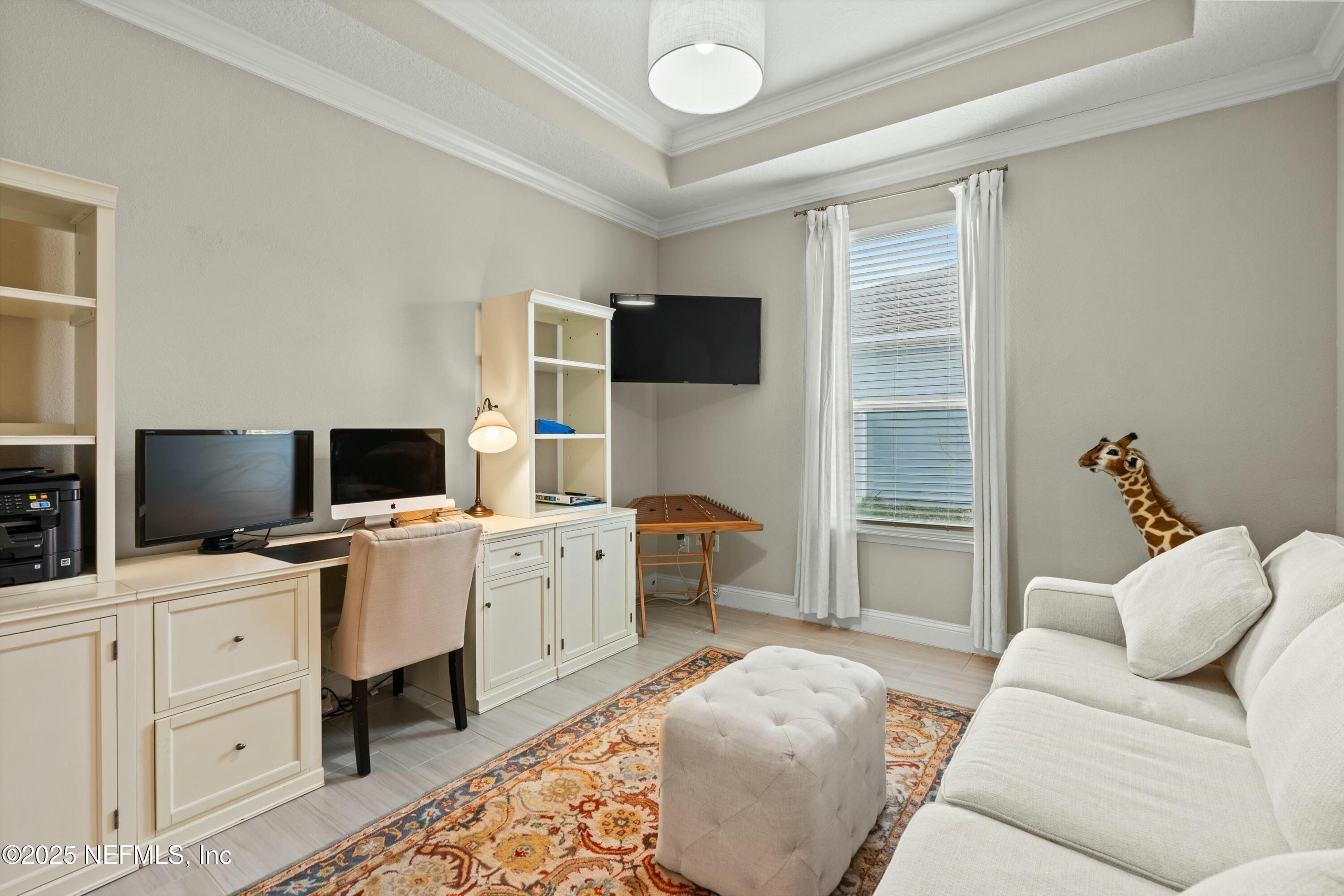 66 Silver Reef Lane St. Augustine, FL 32095 - Photo 16 of 46 a bedroom with furniture and a flat screen tv