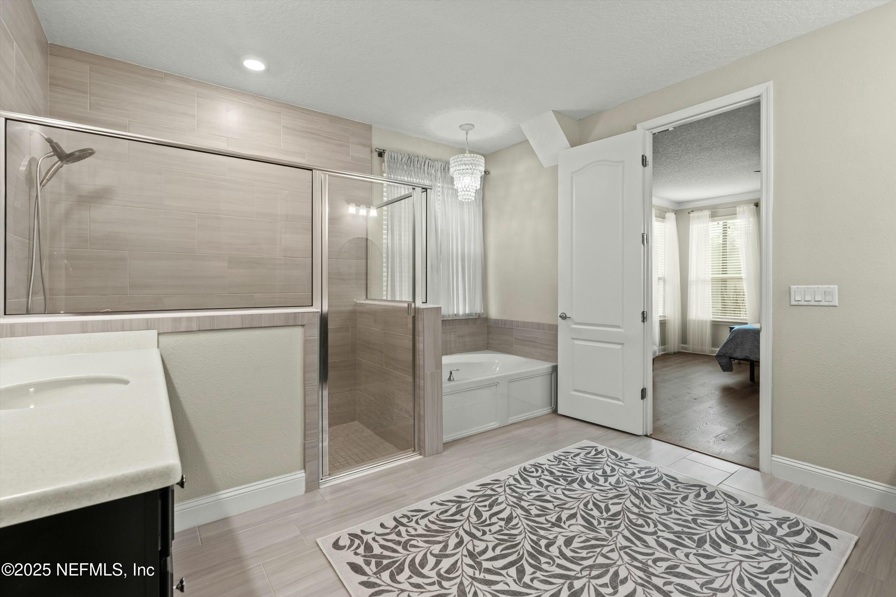 66 Silver Reef Lane St. Augustine, FL 32095 - Photo 27 of 46 a bathroom with a tub and a glass door shower